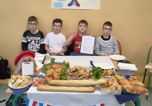 Uczniowie 4 klasy przy stoisku z wypiekami i dekoracjami Francji.