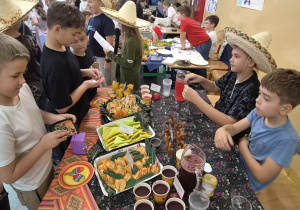Uczniowie odwiedzają meksykańskie stoisko i kupują przygotowane potrawy.