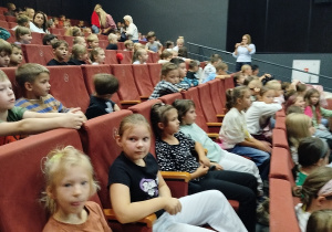 Dziewczynki i chłopcy na sali teatralnej.