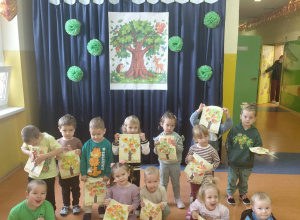 Grupa „Zielone Żabki” na tle dekoracji z okazji Dnia Drzewa.