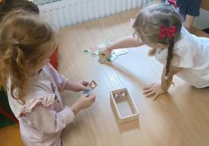 Podczas Dnia Gier Planszowych dziewczynki ćwiczyły spostrzegawczość i koncentrację, układając domino obrazkowe.