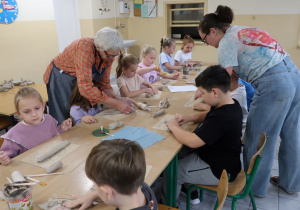 Uczniowie klasy 1 podczas warsztatów ceramicznych wraz z paniami.
