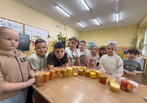 Dzieci z klasy pierwszej pokazują, ile soku wycisnęły z owoców.