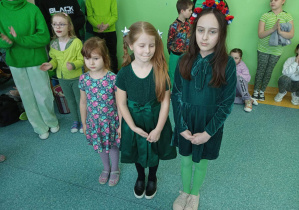 na pierwszym planie trzy nagrodzone dziewczynki w konkursie na zielony strój z elementami wiosny na tle pozostałych uczniów.