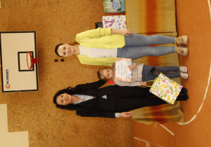 na zdjęciu znajdują się dwie dorosłe kobiety i jedno dziecko z dyplomem w ręku
