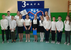 uczniowie występujący na akademii, za nimi po prawej Kierownik Szkoły p. Małgorzata Jakubowska.