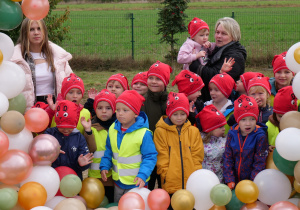 uczniowie w czerwonych czapkach, dookoła balony