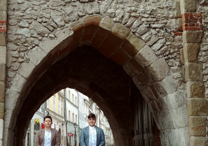 chłopcy przed bramą prowadzącą na stare miasto w Krakowie
