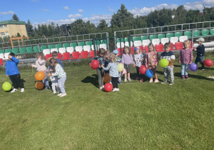 Dzień Kropki w grupie Motylki – dzieci gonią balonowe kropki po boisku , zabawa ruchowa.