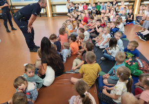 Dzieci zadają pytania policjantom.