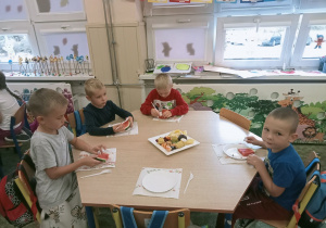 Dzieci z grupy Krasnale ze smakiem zjadają soczyste owoce.