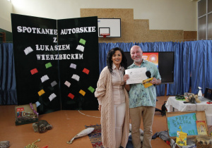 Pani Dyrektor Szkoły Agata Ewa Ostalska wręcza podziękowanie za spotkanie autorskie Łukaszowi Wierzbickiemu.