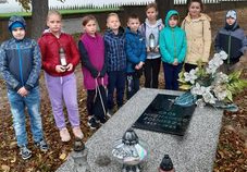 Grupa uczniów przy grobie