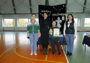 na zdjęciu widnieją trzy dorosłe kobiety oraz dziecko z nagrodami i dyplomem