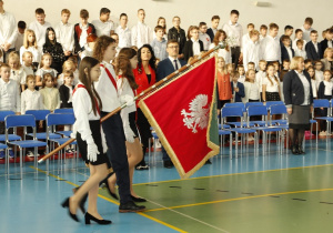 Delegacja uczniów wprowadza sztandar szkolny.