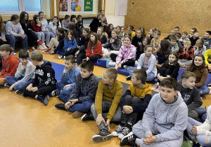 grupa uczniów z klas IV – VI siedząca na materacach podczas spotkania z panią psycholog