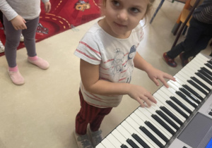 Dziewczynka gra na keyboardzie.