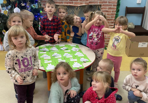 Grupa dzieci pokazuje wykonane kartki świąteczne.