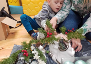 Chłopiec dekoruje stroik świąteczny