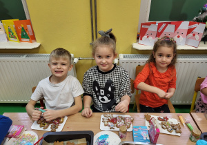 Chłopiec i dziewczynki pisakami dekorują pierniki.
