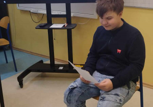 1.Zdjęcie przedstawia chłopca siedzącego w klasie, który czyta.