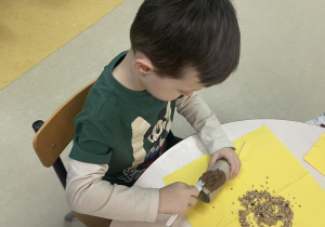 Chłopiec smarujący rolkę czekoladą.