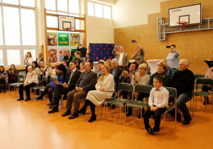 Zaproszeni goście oglądają program artystyczny w wykonaniu grupy Krasnoludki.