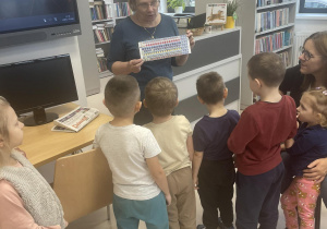 Dzieci oglądają jakie naklejki dostają dzieci na swoje karty biblioteczne.