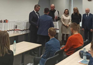 Wojtek odbiera nagrodę i dyplom od komisji w auli CRE