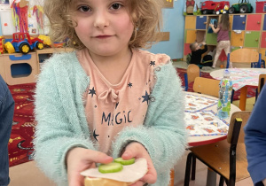 Dziewczynka prezentuje samodzielnie zrobioną kanapkę.