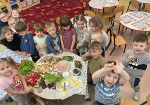 Grupowe zdjęcie dzieci przedszkolnych przy szwedzkim stole.