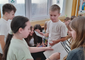 na zdjęciu ukazana jest grupa uczniów klasy 5, którzy rozwiązują quiz o Irlandii przy pomocy tabletu i kodów QR