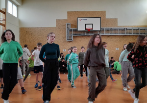 na zdjęciu widzimy liczną grupę dzieci, tańczących taniec irlandzki w Sali gimnastycznej