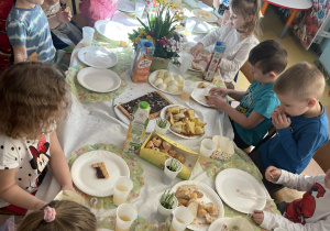 Dzieci dzielą się jajkiem podczas śniadania Wielkanocnego.