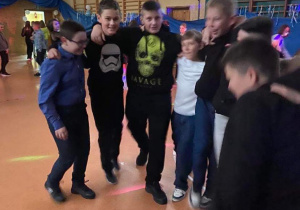zdjęcie ukazuje grupę tańczących i uśmiechniętych chłopców