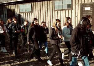 uczniowie zwiedzają budynki obozowe