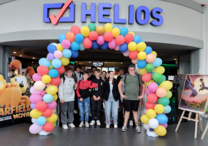 Uczniowie klasy 7 b pod łukiem z balonów w wejściu do kina