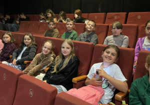 grupa uczniów w kinie oczekuje na projekcję filmu