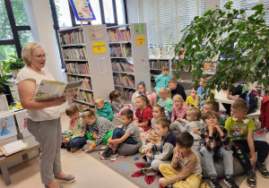 Pani bibliotekarz czyta dzieciom książkę pt Idziemy do pierwszej klasy.