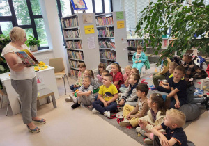 Pani bibliotekarka pokazuje dzieciom książeczki z dźwiękami. .