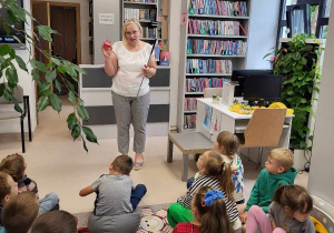 Pani bibliotekarka trzyma w ręku zakładkę do książki.