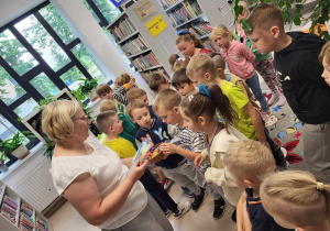 Pani Grażyna częstuje dzieci cukierkami.