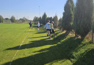 Chłopcy z klasy VIb zbierają śmieci na boisku kompleksu rekreacyjno-sportowego.