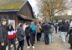 Uczniowie pod bramą z napisem „Arbeit macht frei".