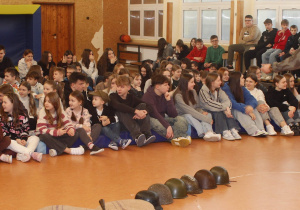 Sala gimnastyczna oraz uczniowie podczas występu historycznego.