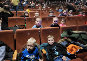 Dzieci z grupy Krasnoludków i Motylków siedzą wygodnie w fotelach i uważnie oglądają przedstawienie.