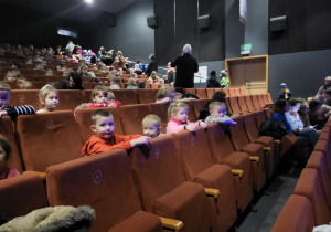 Przedszkolaki z grupy Krasnoludków słuchają i oglądają aktorów na scenie.