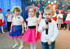 Chłopiec w towarzystwie dziewczynek recytuje wiersz.