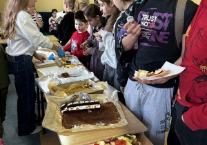 Zadowoleni uczniowie Szkoły Podstawowej w Rzeczycy uczestniczą w kiermaszu słodko- słonym.