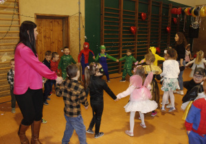 Grupa Misie w strojach karnawałowych z pedagogiem specjalnym Agnieszką tańczą w kółeczku